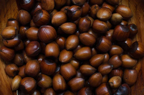 Hazelnoten verspreid over boards, gefotografeerd van bovenaf, vormen een uniforme achtergrond — Stockfoto