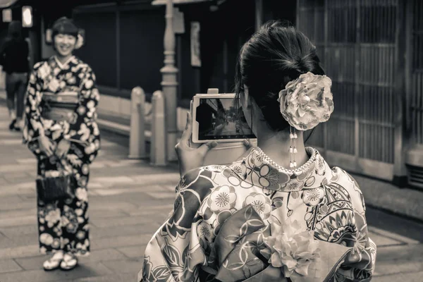 日本女孩在传统的夏季和服浴衣上 用日本最后一部科技手机互相拍照 — 图库照片