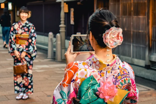 在日本金泽老城 穿着和服的日本女孩用手机互相拍照 — 图库照片