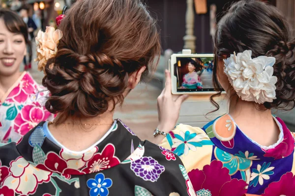 日本女孩在传统的五颜六色的和服拍照的朋友与最新的 Iphone — 图库照片