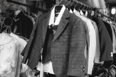 Kıyafet pazarında elbise askısında asılı şık küçük gantleman takımları.