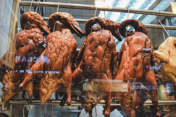 Roasted smoked ducks hanged the window of a Chinese restaurant in Hong Kong