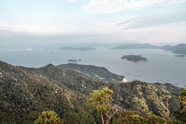 Japonya 'nın Hiroşima adasındaki Miyajima adasındaki Misen Dağı' ndan güzel ormanlar, bulutlu gökyüzü ve inci çiftlikleri.