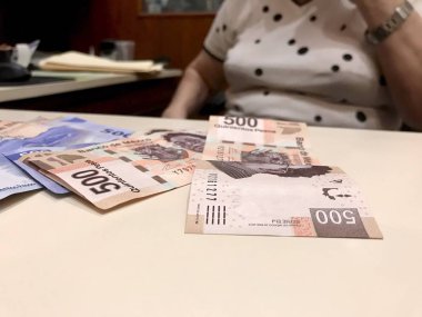 Meksika Pezosu faturaları üzerinde bej bir Resepsiyon yaymak çok karışık