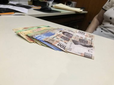 Meksika Pezosu faturaları üzerinde bej bir Resepsiyon yaymak çok karışık