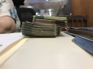 Bazı Meksika pezosu para faturaları bej renkli bir masaya yığılmış