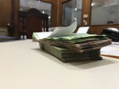 Bazı Meksika pezosu para faturaları bej renkli bir masaya yığılmış