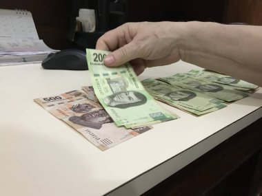 Bazı Meksika peso faturaları dağıtılan ve bej renkli bir masaya yayıldı