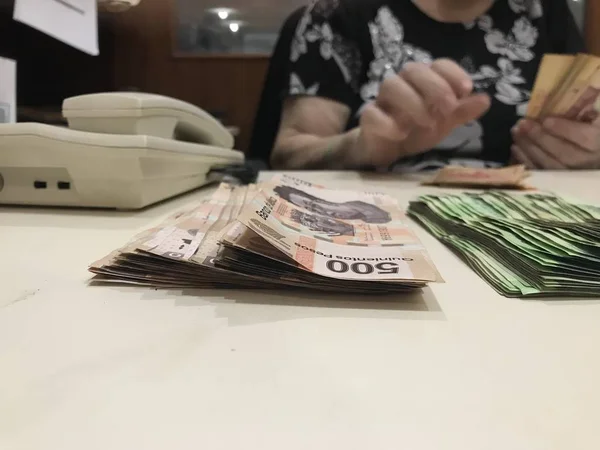 Some 500 mexican bank note bills stacked on a beige coloured table — Stock Photo, Image