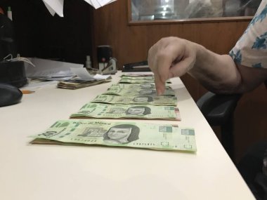 Birçok Meksika peso faturaları dağıtılan ve bej renkli bir masaya yayıldı