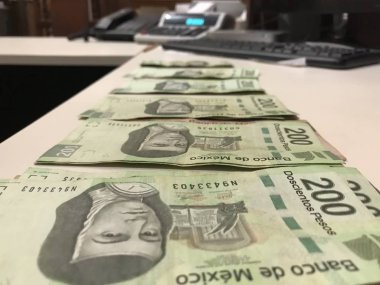 Birçok Meksika peso faturaları dağıtılan ve bej renkli bir masaya yayıldı