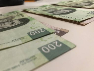 Beş yüz iki yüz Meksika pesosu birçok faturaları dağıtılan ve bej renkli bir masaya yayıldı