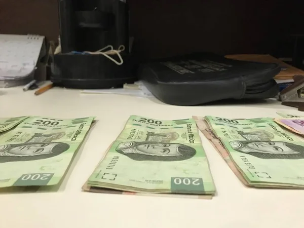 Многие мексиканские песо банкноты распространяются и распространяются на бежевом столе — стоковое фото