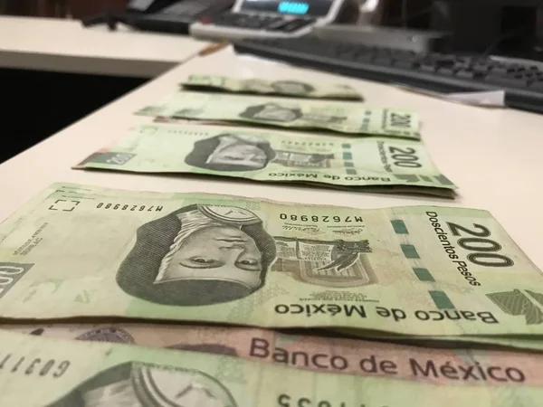 Banyak tagihan peso Meksiko didistribusikan dan disebarkan di meja berwarna krem — Stok Foto