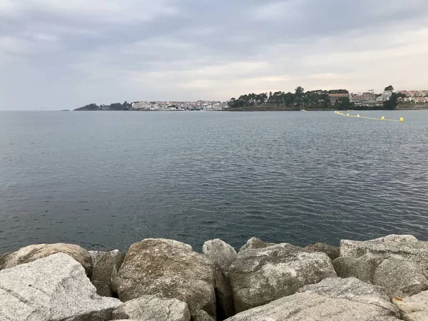 View of the sea and the rocks from the seafront of Silgar beach in Sanxenxo during a cloudy day in summer — Stock Photo, Image