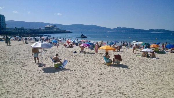 Menschen am Strand in Sanxenxo Spanien mit Madame de Silgar im Hintergrund — Stockfoto