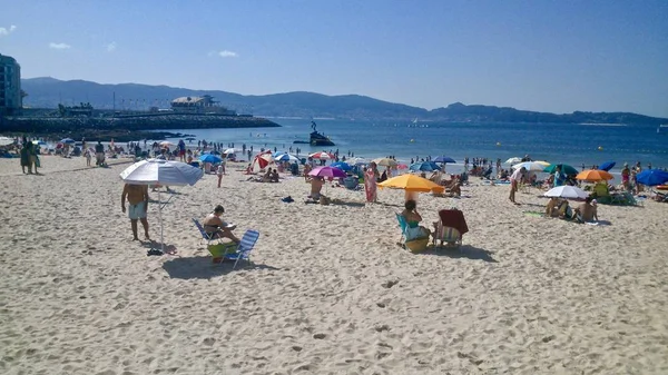 Les gens à la plage à Sanxenxo Espagne avec Madama de Silgar en arrière-plan — Photo