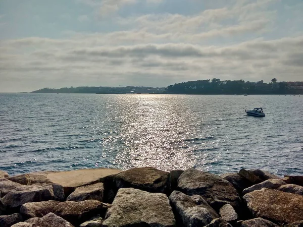 Rotsachtige kust met zon reflectie tijdens een bewolkte dag in Sanxenxo in Spanje — Stockfoto