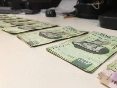 Birçok Meksika peso faturaları dağıtılan ve bej renkli bir masaya yayıldı