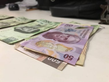 Birçok Meksika peso faturaları dağıtılan ve bej renkli bir masaya yayıldı