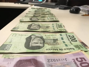Birçok Meksika peso faturaları dağıtılan ve bej renkli bir masaya yayıldı
