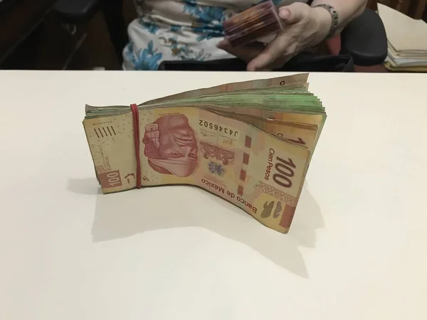 Néhány Mexikói peso pénz számlák halmozott egy bézs színű asztal — Stock Fotó