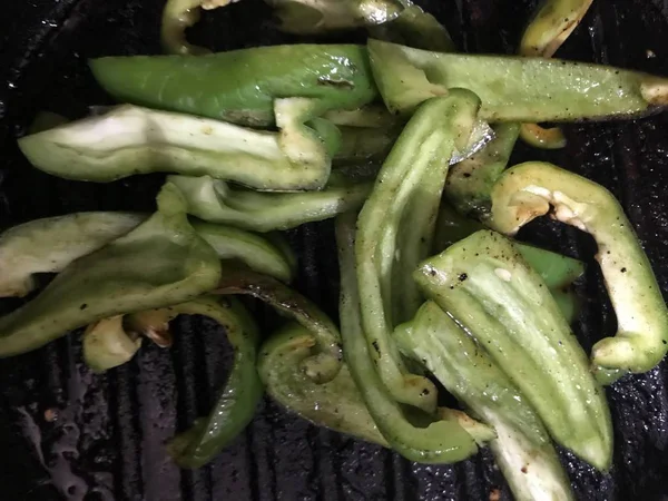 Peperone verde in strisce che friggono su una padella di ferro nera — Foto Stock