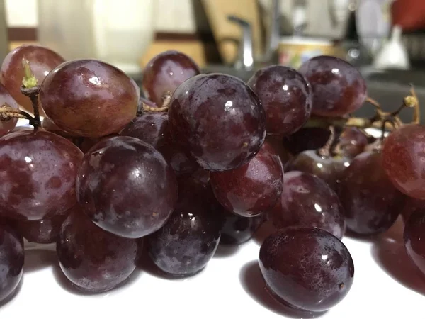 Ramo de uvas encima de una fuente de acero inoxidable —  Fotos de Stock