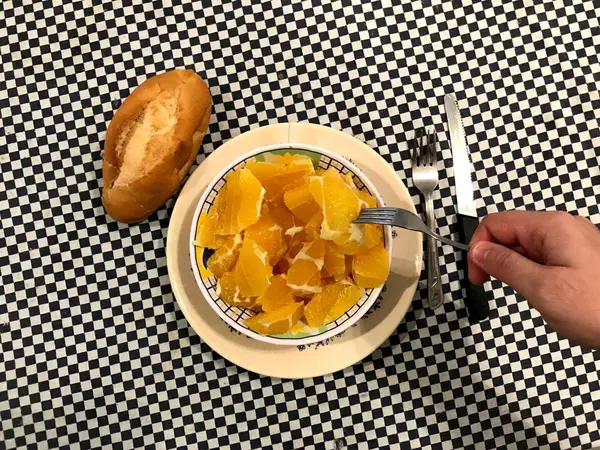 Draufsicht auf eine Schüssel mit gehackten Orangen mit einem Stück Brot links — Stockfoto