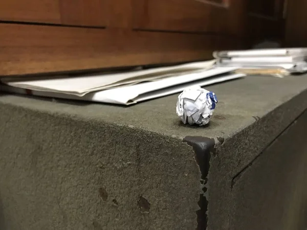 Weiße und blaue Papierkugel am Rand in der Ecke eines alten, grauen Safes — Stockfoto