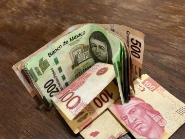 Birçok karışık Meksika pezosu faturaları ahşap bir masa üzerine yayılmış
