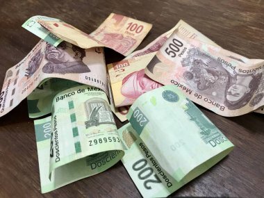 Birçok karışık Meksika pezosu faturaları ahşap bir masa üzerine yayılmış