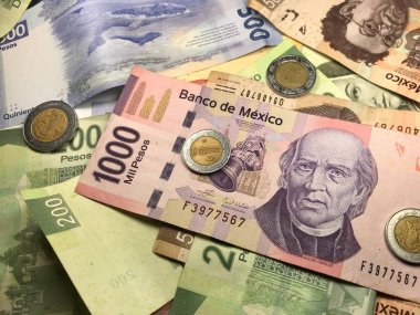 Birçok karışık Meksika pezosu faturaları ahşap bir masa üzerine yayılmış