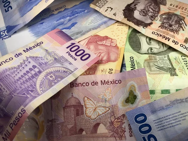 Beaucoup de billets de peso mexicain mélangés répartis sur un bureau en bois — Photo