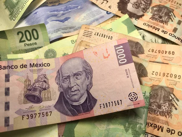Beaucoup de billets de peso mexicain mélangés répartis sur un bureau en bois — Photo