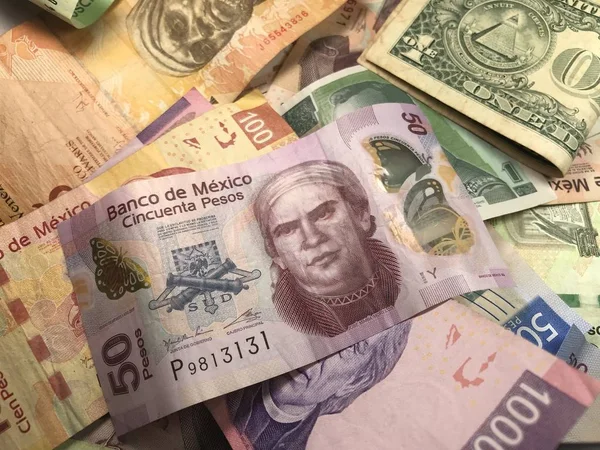 Många blandade mexikanska peso räkningar spridda över ett trä skrivbord — Stockfoto