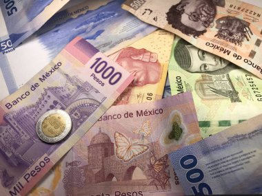 Birçok karışık Meksika pezosu faturaları ahşap bir masa üzerine yayılmış