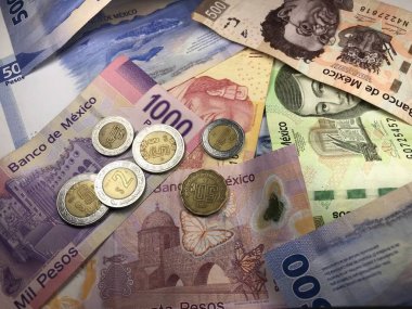 Birçok karışık Meksika pezosu faturaları ahşap bir masa üzerine yayılmış