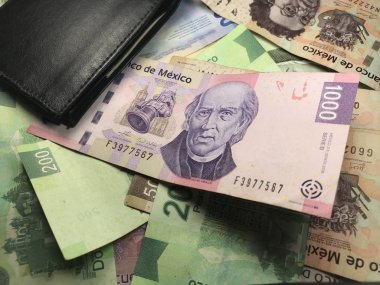 Birçok karışık Meksika pezosu faturaları ahşap bir masa üzerine yayılmış
