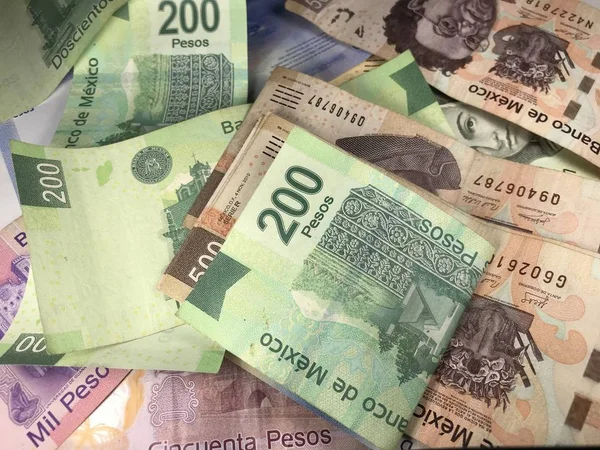 Viele gemischte mexikanische Peso-Scheine auf einem Holztisch verteilt — Stockfoto