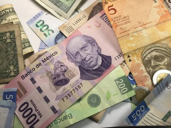 Muchos billetes mixtos de peso mexicano repartidos sobre un escritorio de madera —  Fotos de Stock