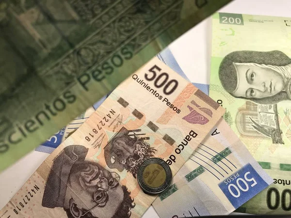 Muchos billetes mixtos de peso mexicano repartidos sobre un escritorio de madera —  Fotos de Stock