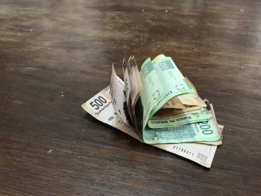 Birçok karışık Meksika pezosu faturaları ahşap bir masa üzerine yayılmış