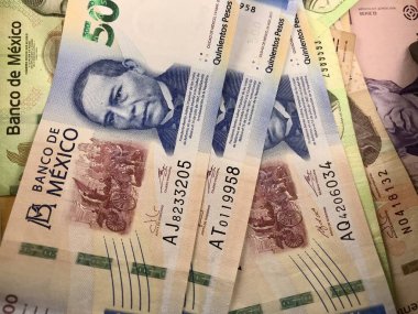 Bazı Meksika peso faturaları ahşap bir masaya yayılmış