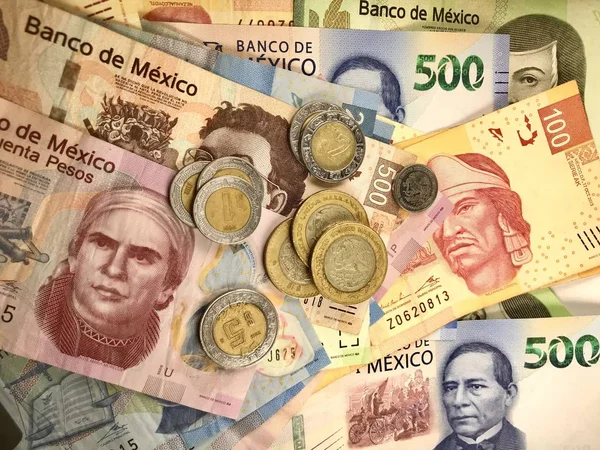 Algumas contas de pesos mexicanos espalhadas por uma mesa de madeira — Fotografia de Stock