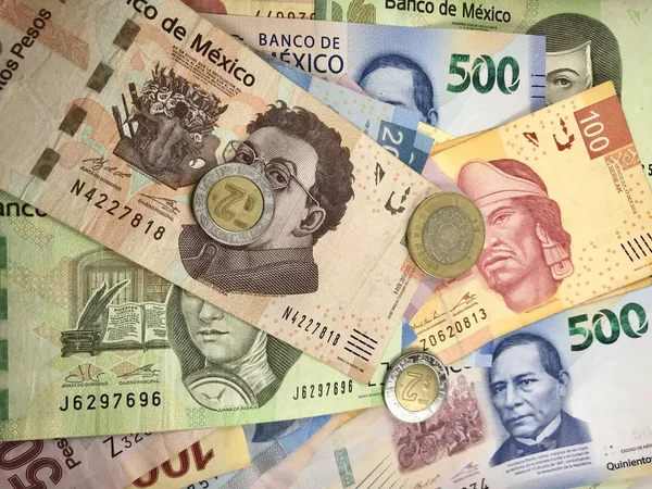 Algumas contas de pesos mexicanos espalhadas por uma mesa de madeira — Fotografia de Stock