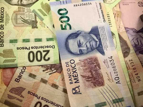 Some mexican pesos bills spread over a wooden desk — Stock Photo, Image