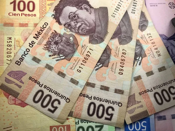 Billetes de peso mexicano distribuidos aleatoriamente sobre una superficie plana — Foto de Stock