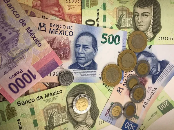 Billetes de peso mexicano distribuidos aleatoriamente sobre una superficie plana — Foto de Stock