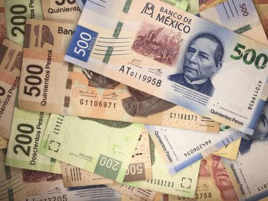 Mexican peso bills spread randomly over a flat surface clipart